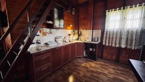a kitchen with wooden cabinets and a staircase in a house at Kaba Saradiel Cabin in Mawanella