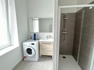 a bathroom with a washing machine and a washer at Les Remparts, centre-ville d'Hennebont in Hennebont