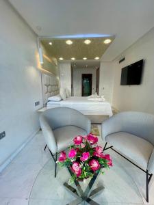 Cette chambre comprend 2 lits et une table fleurie. dans l'établissement Appartement al aamira, à Tanger