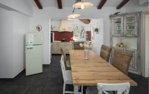 a kitchen with a wooden table and a refrigerator at Holiday Home Kranjci Kranjci in Raša