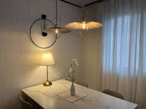 a table with a vase of flowers and two lights at Naroo Stay - DDP and Jong-ro in Seoul