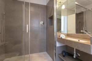 a bathroom with a glass shower and a sink at Genteel Home Padre Marchena in Seville