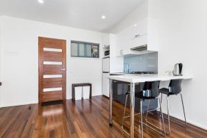 a kitchen with a white counter top and a table at Seafarers Getaway in Apollo Bay