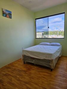 een slaapkamer met een bed en een groot raam bij Casa Mandacaru in Ubajara
