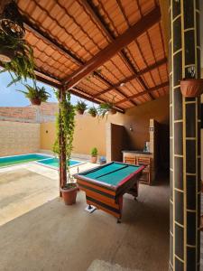 een pooltafel in een patio naast een zwembad bij Casa Mandacaru in Ubajara