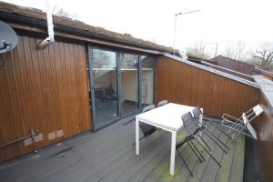 a patio with a table and chairs on a deck at Sudbury Place in Harrow on the Hill