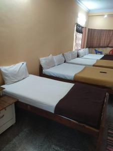 a couple of beds in a room at Dolphin Resort in Yelagiri