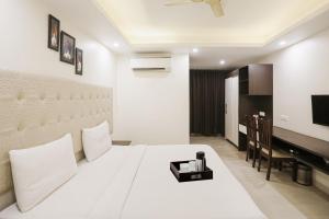 a bedroom with a large white bed and a piano at Super Townhouse The AMV Hotel in Gurgaon