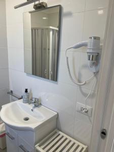 a white bathroom with a sink and a mirror at Loredana Affittacamere in Vittoria +27 photos