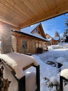 a cabin in the snow with snow on the roof at Apartament Borowikowe Zacisze in Falsztyn