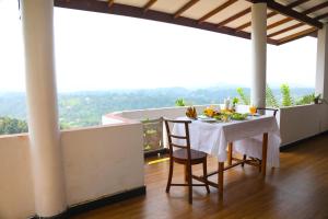 a table and chairs on a balcony with a view at Mountain Bliss Villa Peradeniya in Peradeniya +106 photos
