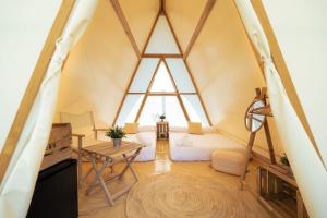 a room in a frame house with a bed and a table at Kampaoh Cabañeros in Navas de Estena