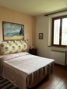 a bedroom with a bed and a painting on the wall at Agriturismo Morisfarms - Podere Cancelloni in Massa Marittima