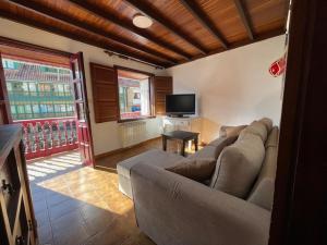 a living room with a couch and a tv at Tazones Asturias Casa de pescadores in Tazones
