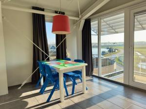 a dining room table with blue chairs and a red lamp at Appartementen Casa del Lago in Lisse