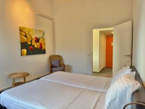 a bedroom with a bed and a painting of tulips at Appartementen Casa del Lago in Lisse