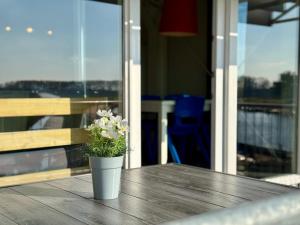 a vase with flowers sitting on a wooden table at Appartementen Casa del Lago in Lisse