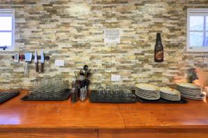 a counter with plates and cups and a bottle of wine at Hostel Familia de Campo in El Chalten