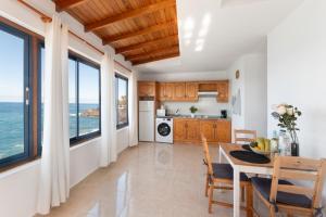 una cocina con mesa y sillas y el océano en La Bayana Apartments - 8, en Puerto Naos