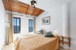 Un dormitorio con una cama en una habitación con ventanas. en La Bayana Apartments - 8, en Puerto Naos 22 fotos más