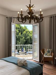 1 dormitorio con 1 cama y balcón con lámpara de araña. en VISTA PLAZA - Exceptional Location, en Los Llanos de Aridane