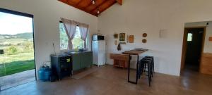 a kitchen with a refrigerator and a table in it at Sítio Âmbar - Piscina, Wi-fi e lago de pesca ! in Lambari