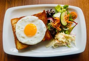 a white plate with an egg on toast and a salad at The Ferry Boat Inn in Ullapool