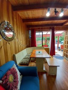 a living room with a blue couch and a table at Cabaña con muro de escalada in Pucón