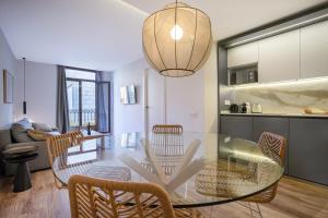 een eetkamer en een keuken met een glazen tafel en stoelen bij Happy Apartments in Barcelona