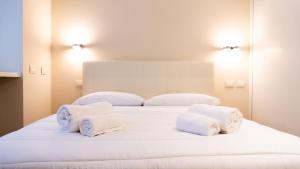 a bedroom with a white bed with towels on it at Luxury Flat - WiFi, AC, Walk to Brera & Duomo in Milan