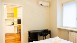 a bedroom with a desk with a chair and a window at Luxury Flat - WiFi, AC, Walk to Brera & Duomo in Milan