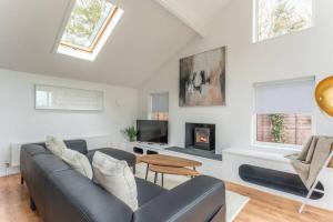 a living room with a couch and a fireplace at Luxury self contained one bedroom - Sawbridgeworth in Sheering