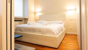 a bedroom with a white bed with towels on it at Luxury Flat - WiFi, AC, Walk to Brera & Duomo in Milan