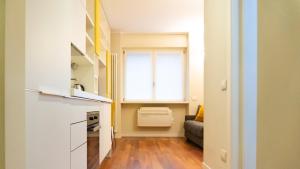a small living room with a window and a couch at Luxury Flat - WiFi, AC, Walk to Brera & Duomo in Milan