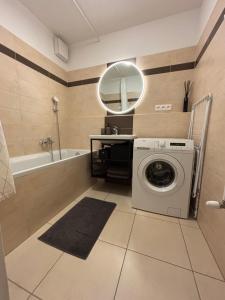 a bathroom with a washing machine and a mirror at Self check in with parking included in Bratislava