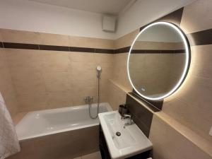a bathroom with a sink and a mirror and a tub at Self check in with parking included in Bratislava +11 photos