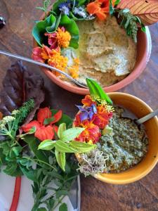 a table topped with two bowls of food and flowers at Casa Natura Galicia in Santa María La Mayor del Rosario