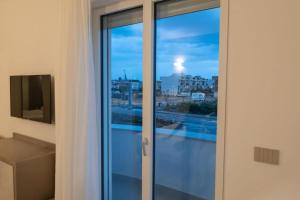 a sliding glass door with a view of a city at Home Design La Vela in Zapponeta