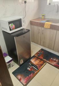 a kitchen with a microwave on top of a refrigerator at Homes by lucy in Mombasa