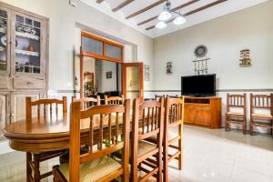 a dining room with a table and chairs and a tv at Tío Salvador in Bolbaite
