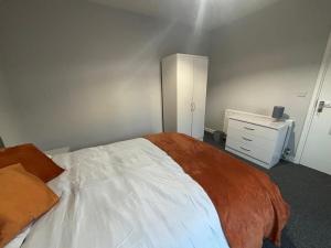 a bedroom with a large bed and a dresser at Perfect for NHS Staff & Contractors - Fast WiFi - 1 Bedroom in 4 Bedroom House CD1 in Scartho