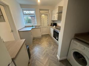 a kitchen with a washer and dryer in a kitchen at Perfect for NHS Staff & Contractors - Fast WiFi - 1 Bedroom in 4 Bedroom House CD1 in Scartho