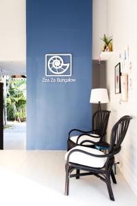 twee stoelen en een lamp voor een blauwe muur bij Zea Za Bungalow in Hua Hin