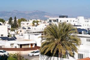 a city with white buildings and a palm tree at Mountain View Suite in Ayios Dhometios