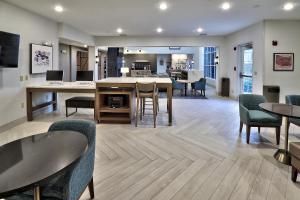 an open living room with chairs and a table at Staybridge Suites - Albuquerque Airport by IHG in Albuquerque