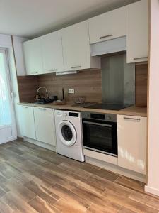 a kitchen with a stove and a washing machine at Appartement Cosy Mulhouse in Mulhouse +5 photos