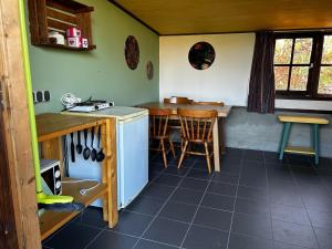 a kitchen with a counter and a table and chairs at Schuilstal in Elim