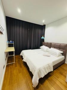 a bedroom with a large white bed with black curtains at URBAN COZY HOME at SkySuites Near KLCC Complimentary Breakfast in Kuala Lumpur