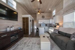 ein Wohnzimmer mit Couch und Küche in der Unterkunft Cozy 1BR Tiny Home with Pool Access and Free Tix in Flat Rock