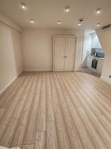 an empty room with a wooden floor and a door at Deluxe Urban Retreat Studio Apartment in London